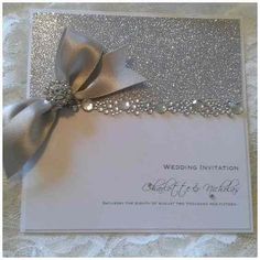 a wedding card with a silver bow on it