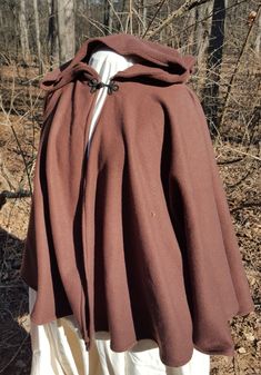 the back of a brown jacket on a mannequin's head in front of trees