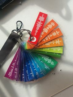 a bunch of different colored tags sitting on top of a white table next to a pair of scissors