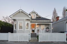 a white house with a picket fence in front of it