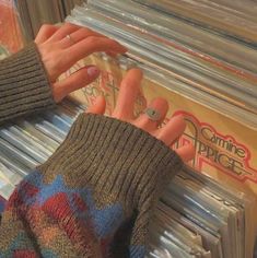 two hands reaching for records in a record store