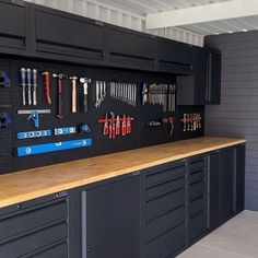 an organized workbench with many tools on the wall and hanging from hooks,