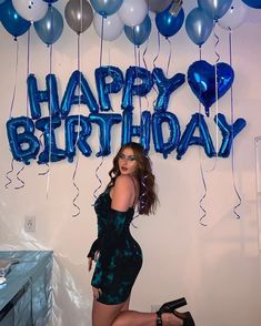 a woman is posing in front of balloons that say happy birthday