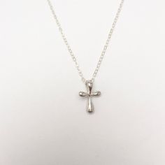 A gorgeous tiny and simple, Sterling Silver cross hangs delicately from a Sterling Silver chain. This small, slightly puffy cross has softly rounded edges and is super smooth. Available in Sterling Silver or Gold Vermeil. A beautiful keepsake piece of jewelry or gift for a baptism or dedication that will last a lifetime. - Pendant - Sterling Silver or Gold Vermeil - 13mm x 9mm (Made in the USA) - Chain + components - Sterling Silver or 14K Gold-Fill - Clasp - Sterling Silver or 14K Gold-filled l Affordable Silver Cross Pendant Jewelry, Small Silver Cross Necklace, Minimalist Cross Pendant Necklace For First Communion, Everyday Cross Pendant Charm Necklace, Delicate Everyday Cross Necklace, Minimalist Cross Pendant Necklaces For Baptism, Minimalist Cross Pendant Necklace For Baptism, Minimalist Cross Jewelry For First Communion, Minimalist Cross Jewelry For Baptism