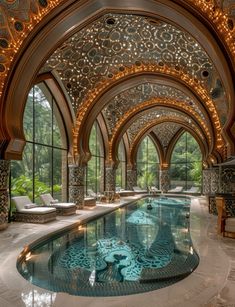 a large indoor swimming pool with an intricate design on the wall and ceiling above it