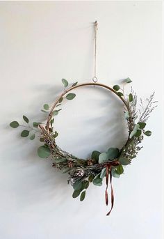 a wreath hanging on the wall with greenery