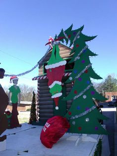 christmas decorations on display in front of a log cabin with santa's stocking hanging from the roof