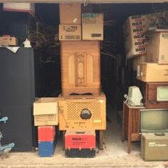 a room filled with lots of different types of appliances and boxes on top of each other