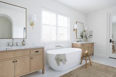 a large white bath tub sitting next to a wooden cabinet in a bathroom on top of a hard wood floor