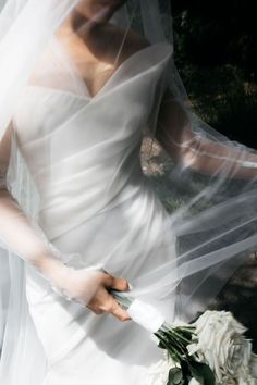 a woman in a wedding dress holding a bouquet