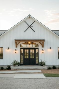 a white building with black doors and two crosses on the front door is lit up at night