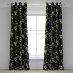 a black and green floral curtain hanging in front of a window