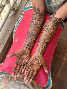 a woman's hands with henna tattoos on them