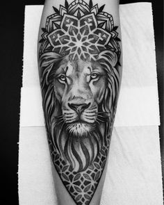 a black and white photo of a lion tattoo on the left leg, with an intricate design