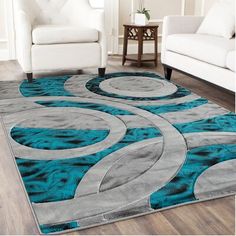 an area rug with blue and grey circles on it in a living room next to two white chairs