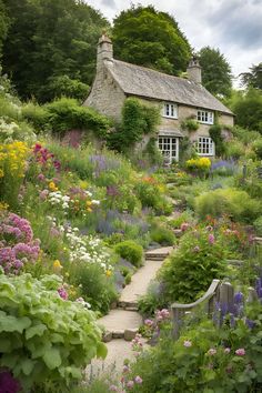 a house surrounded by flowers and greenery with steps leading up to the front door