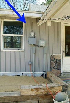 a house that has some sand in front of it and an air conditioner on the outside