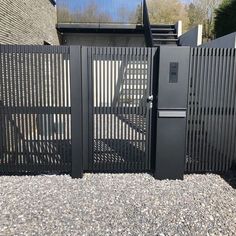 a black metal gate and some rocks in front of a building