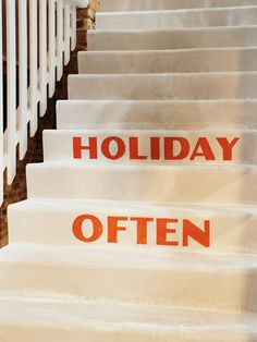 there is a set of stairs that have red lettering on them and the words holiday often appear to be written in orange