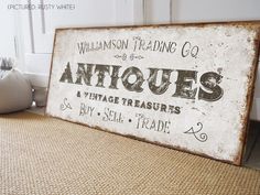 an antique sign is sitting on the floor