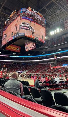 a basketball game is being played in a large arena with people sitting on the bleachers