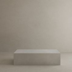 a white rectangular object sitting in the middle of a room with concrete walls and flooring