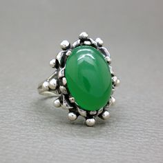 A dramatic design antique Biedermeier Victorian style ring. A large green chrysoprase cabochon is set in a beautifully hand crafted solid silver setting. The ring will be shipped in a gift box. Green Chrysoprase is a variety of chalcedony, which is a type of quartz, and is one of the more valuable stones of this group. Chrysoprase is known as a traditional birthstone of May. Ring size: 10 (US) / T 1/2 (UK) / diameter 19.8 mm / European size: 62 1/4 - it is a big size ring Ring face measures over Green Oval Cabochon Emerald Ring For Wedding, Green Emerald Oval Cabochon Ring For Wedding, Heirloom Green Emerald Oval Cabochon Ring, Heirloom Green Oval Cabochon Emerald Ring, Green Oval Gemstone Cabochon, Green Gemstone Cabochons, Classic Green Cabochon Emerald Ring, Antique Green Oval Cabochon Ring, Vintage Chrysoprase Ring Jewelry