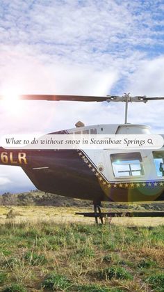 a helicopter sitting on top of a grass covered field