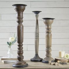 three wooden candlesticks sitting on top of a table