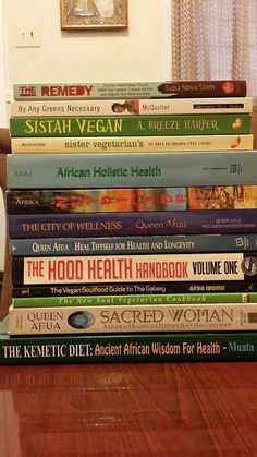 a stack of books sitting on top of a wooden table