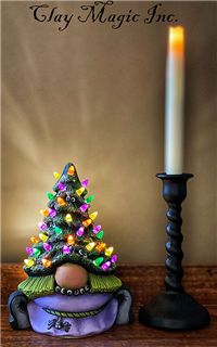 a small christmas tree sitting next to a lit candle