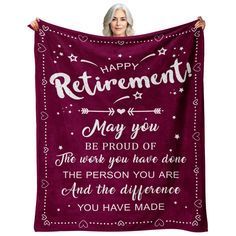 a woman holding up a purple blanket with the words, happy retirement and stars on it