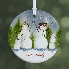 a christmas ornament with three snowmen on it