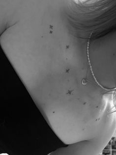 black and white photograph of a woman's chest with stars on her left side