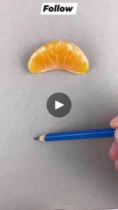 a person holding a pencil in front of an orange