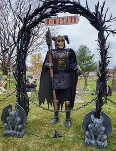 a scarecrow is standing in front of a sign that says boneyard on it