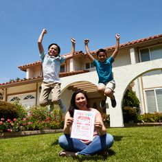 three children jumping in the air with a sign