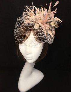 Beautiful apricot and gold veiled fascinator perfect for the guest who wants something Bespoke and unique. This design is a beautiful selection of glass effect leaves and a burst of feathers clustered together amongst a layer of veiling and set onto a fine comfort base tiara band. As with all our designs, this piece can be made exact to the image or in any colour combination to match in with your outfit. If a specific colour is required customers can message over an image of their outfit and acc Gold Spring Wedding Fascinator, Gold Hair Accessories For Spring Wedding, Gold Headpiece For Spring Weddings, Gold Wedding Fascinator With Feathers, Gold Headpieces For Spring Wedding, Gold Wedding Headpiece For Spring, Gold Feathered Fascinator For Party, Gold Headband Fascinator For Wedding, Elegant Gold Fascinator With Feathers