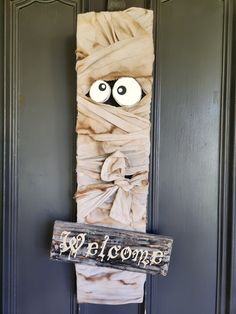 a welcome sign is wrapped in burlock with googly eyes