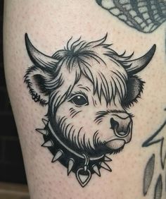 a black and white photo of a bull's head on a woman's thigh