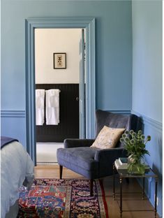 a chair and rug in a room with blue walls