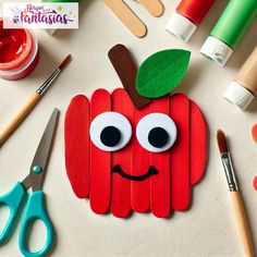 an apple made out of popsicle sticks with eyes, nose and mouth painted on it