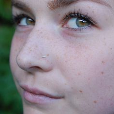 a woman with freckles on her face looking at the camera