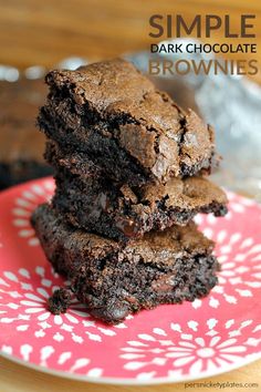 three brownies stacked on top of each other on a pink and white flowered plate