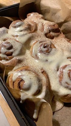 a pan filled with cinnamon rolls covered in icing