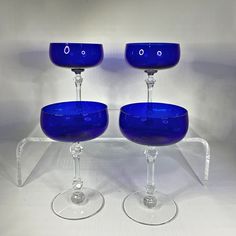 two blue wine glasses sitting next to each other