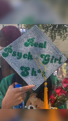 a woman in a green graduation cap with the words good luck on it