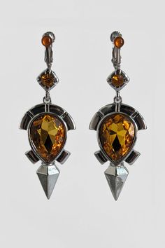 Topaz, a gem that harnesses the power of lightning to increase electrical resistance. With electric enemies on the prowl, you'll need jewelry head gear armor with Shock Resistance! These real life earrings were inspired by the Topaz Earrings worn by Link in the Legend of Zelda Breath of the Wild. The earrings are silver colored and shaped and detailed like in game, complete with a topaz gem center and topaz gem piece on top. Every little detail was carefully replicated as it appears in the Starl Link Cosplay, Gem Top, Zelda Breath Of The Wild, Head Gear, Legend Of Zelda Breath, Amber Earrings, Link Earrings, Zelda Breath, Topaz Earrings