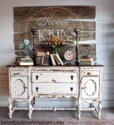 an old dresser is decorated with books and flowers