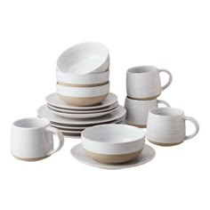 a stack of white dishes and cups sitting next to each other on a white surface